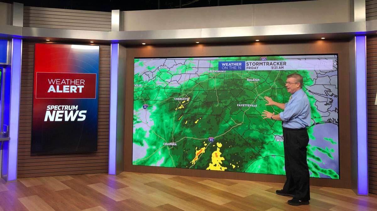 Spectrum News Central NC chief meteorologist Gary Stephenson demonstrates the 13-foot weather wall in the new Spectrum studios in Raleigh.