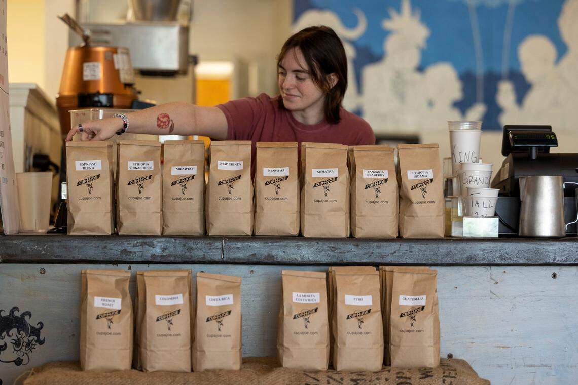 Cashier Zoe O’Brien arranges bags of coffee during the reopening of Cup-A-Joe’s Mission Valley location in Raleigh on Tuesday, June 24, 2025. The café closed in 2021 during the pandemic. Its soft-opening pop-up runs through Friday, June 27, from 8 a.m. to 1 p.m. The shop will close Friday afternoon and reopen Aug. 11.