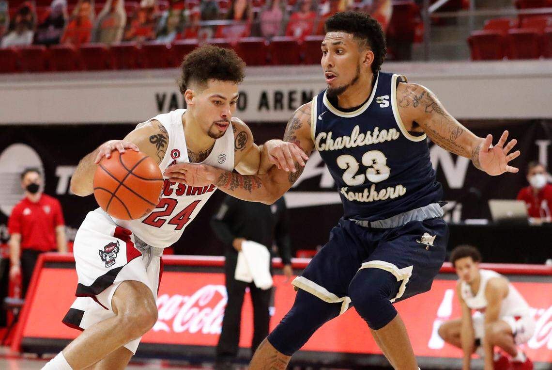 N.C. State’s Devon Daniels (24) drives around Charleston Southern’s Sean Price (23) during the first half in N.C. State’s game against Charleston Southern in the Wolfpack Invitational at Reynolds Coliseum in Raleigh, N.C., Wednesday, Nov. 25, 2020.