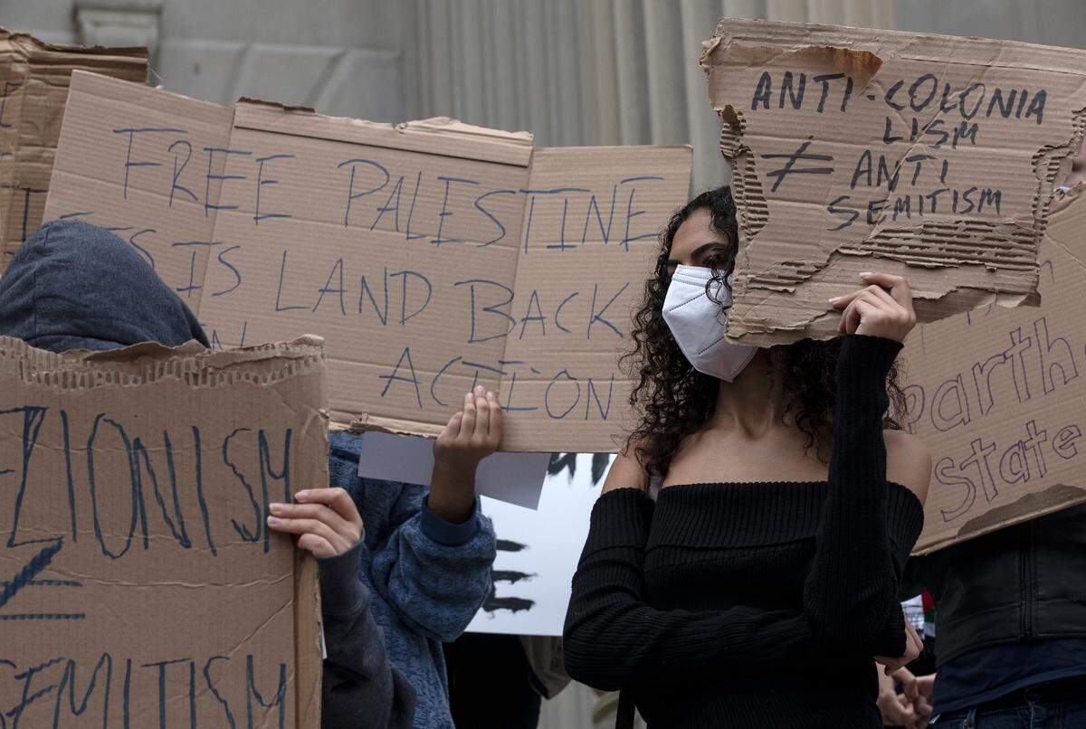 People hold signs during a rally in support of Palestinians at UNC-Chapel Hill on Thursday, Oct. 12, 2023. The rally was organized by the UNC chapter of Students for Justice in Palestine.