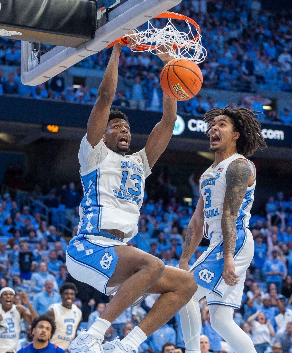 North Carolina guard Elliot Cadeau (3) reacts as teammate Jalen Washington (13) dunks on a Cadeau assist in the second half against American University on Friday, November 15, 2024 at the Smith Center in Chapel Hill, N.C. Cadeau and Washington lead the Tar Heels with 18 point each in their 107-55 victory.