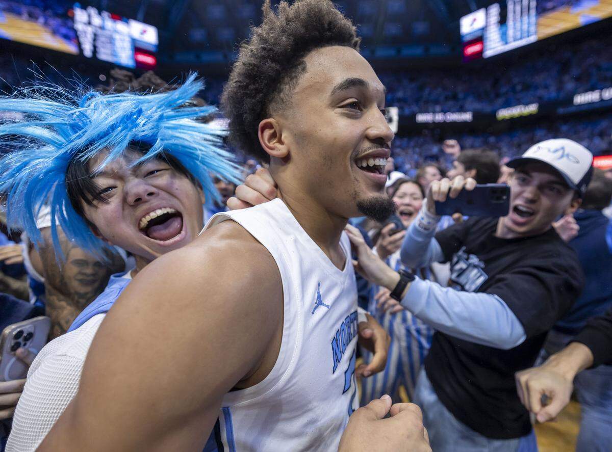 North Carolina guard Seth Trimble (7) reacts as fans storm the court, after sinking a three-point shot with .4 seconds to play, to give the Tar Heels a 71-68 victory over Duke on Saturday, February 7, 2026 at the Smith Center in Chapel Hill, N.C.