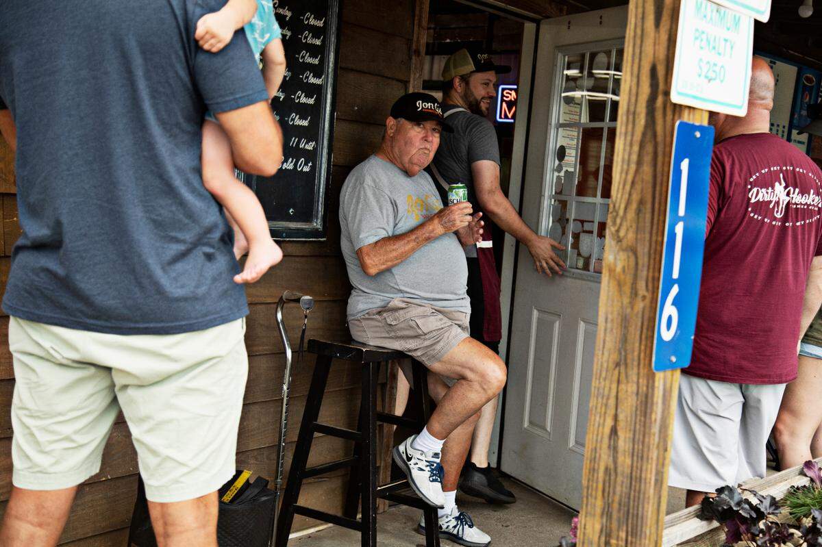 Kelly Kirkman’s dad, Tom Harrington, who goes by “Pops” is the doorkeeper at Jon G’s Barbecue Saturday morning, June 25, 2022. The Peachland restaurant is only open on Saturdays so a long line often forms around the building prior to opening.