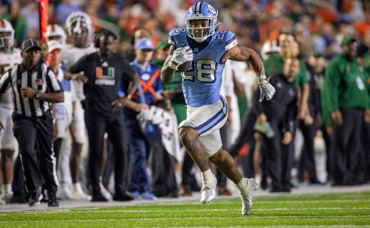 North Carolina running back Omarion Hampton (28) picks up 16-yards on a pass completion from quarterback Drake Maye in the fourth quarter against Miami on Saturday, October 14, 2023 at Kenan Stadium in Chapel Hill, N.C. Hampton rushed for 197 yards and one touchdown in the Tar Heels’ 41-31 victory.