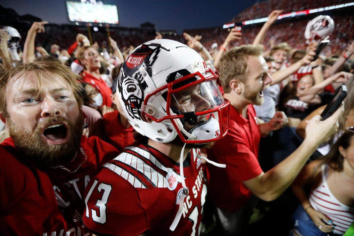 N.C. State quarterback Devin Leary (13) celebrates with fans after N.C. States 27-21 overtime victory over Clemson at Carter-Finley Stadium in Raleigh, N.C., Saturday, Sept. 25, 2021.