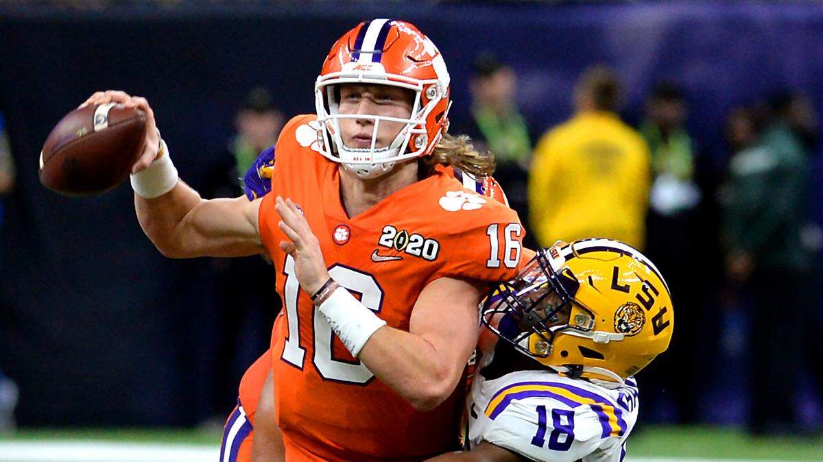 Clemson Tigers quarterback Trevor Lawrence, left, fights to get a pass off as LSU Tigers linebacker K’Lavon Chaisson, right, looks to make the sack during second quarter action at the Mercedes-Benz Superdome in New Orleans, LA. on Monday, January 13, 2020. Clemson and LSU battled in the College Football Playoff National Championship.