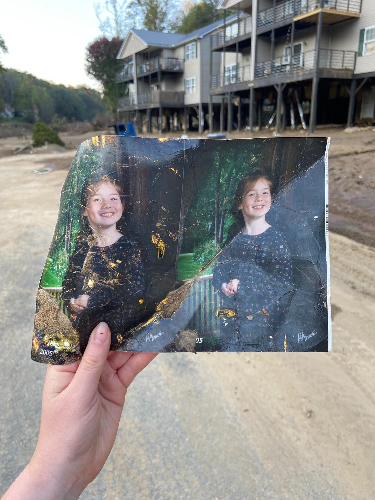 Taylor Schenker holds one of the photos she found along the Swannanoa River after Hurricane Helene