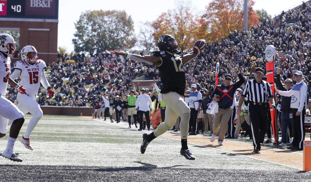 Wake Forest quarterback Jamie Newman (12) celebrates while scoring on a 20-yard touchdown run during the first half of N.C. State’s game against Wake Forest at BB&T Field in Winston-Salem, N.C., Saturday, Nov. 2, 2019.