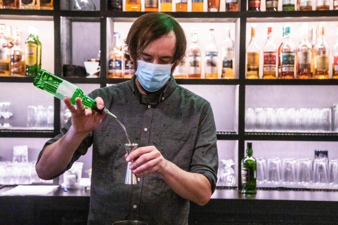 Bartender Lentz Ison mixes a drink at Dram & Draught in Raleigh Friday night, Oct. 2, 2020. The state moved into Phase 3 of its reopening plan Friday at 5 p.m., meaning private bars could open at 30 percent of their outdoor capacity.