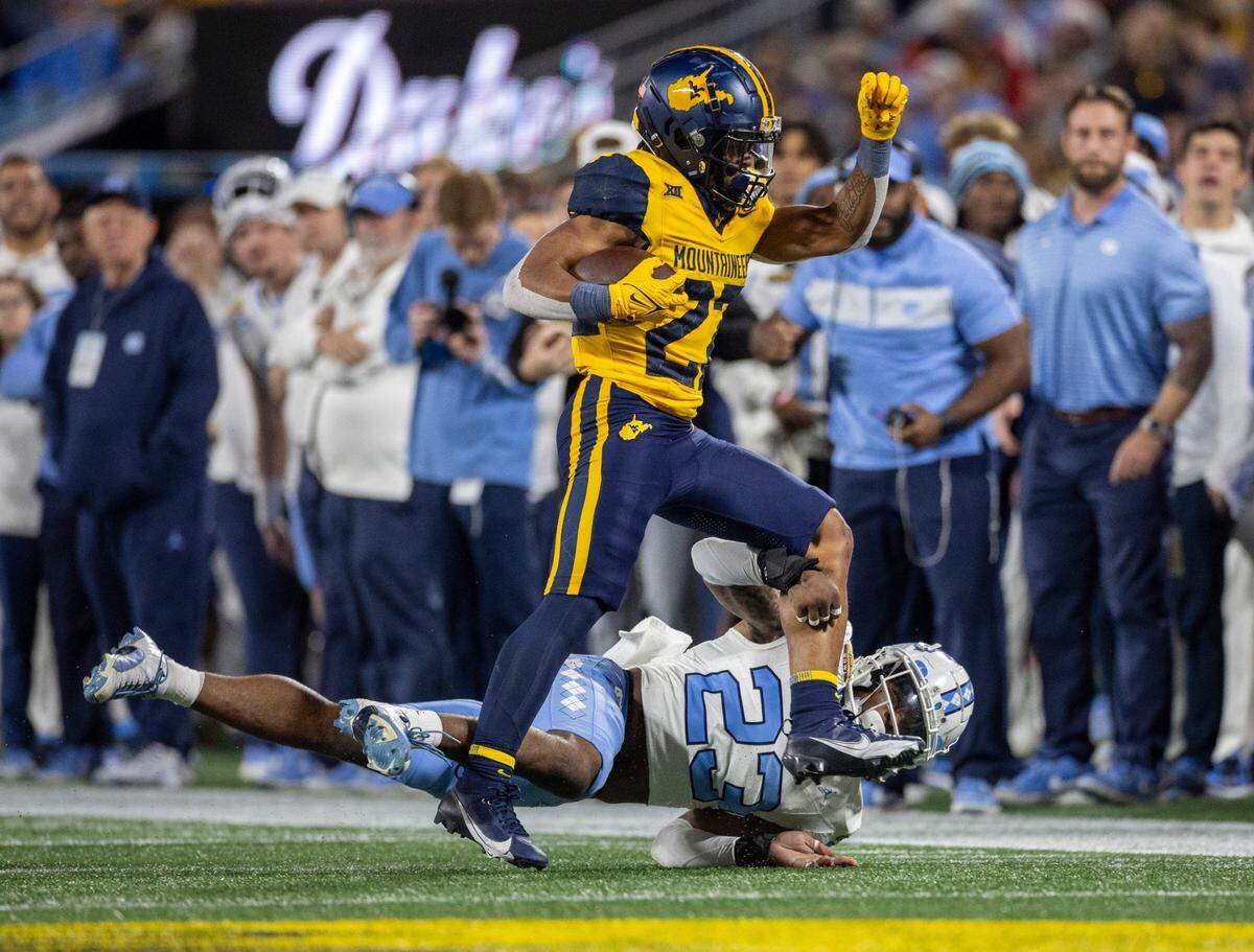 North Carolina’s Power Echols (23) stops West Virginia’s Jaheim White (22) for no gain in the second quarter during the Duke’s Mayo Bowl on Wednesday, December 27, 2023 at Bank of American Stadium in Charlotte, N.C.