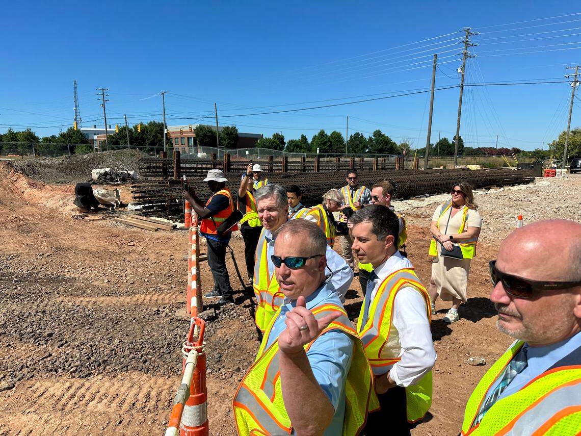 N.C. Department of Transportation engineer Mark Craig describes the planned underpass that will carry Blue Ridge Road under Hillsborough Street and the N.C. Railroad tracks next to the State Fairgrounds in Raleigh. Listening are Gov. Roy Cooper, U.S. Transportation Secretary Pete Buttigieg, center, and state Transportation Secretary Joey Hopkins, right, on Monday, July 1, 2024.