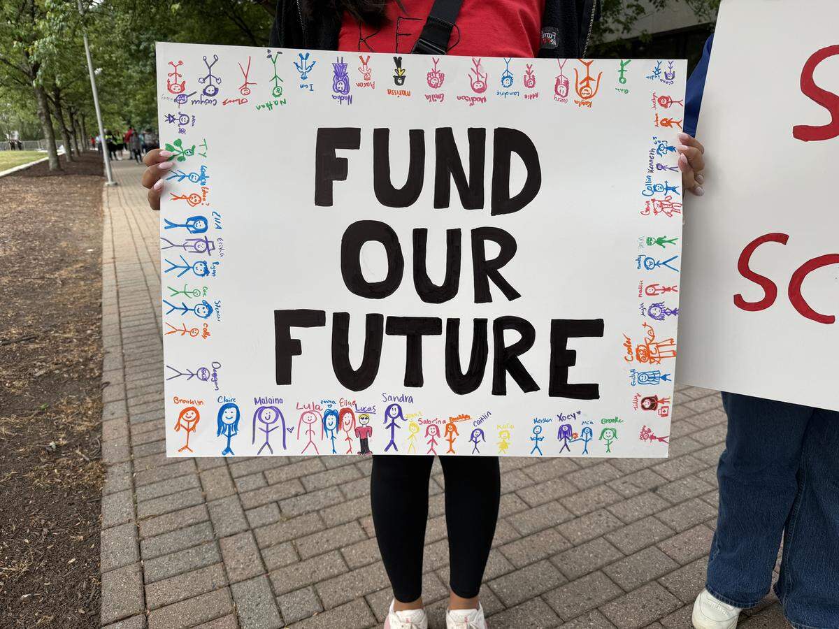 A protester displays their sign supporting teachers before the march in downtown Raleigh.