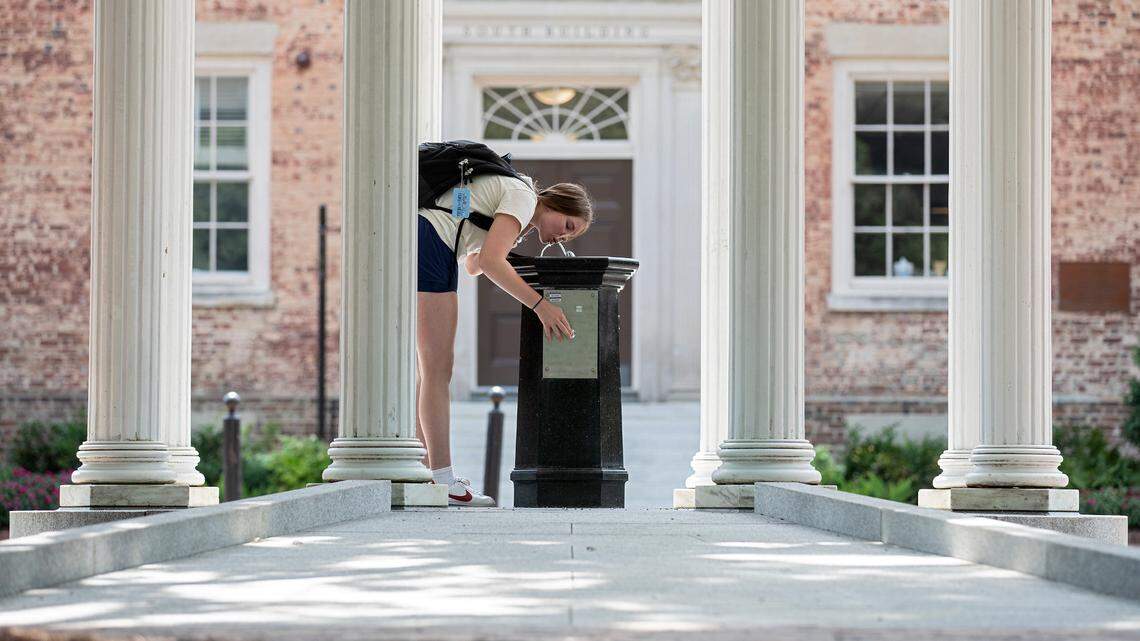 A person drinks from the Old Well on the first day of classes at UNC-Chapel Hill on Monday, Aug. 21, 2023. The university landmark underwent renovations this summer to improve accessibility, including the addition of a sloped ramp and a lowered drinking fountain.