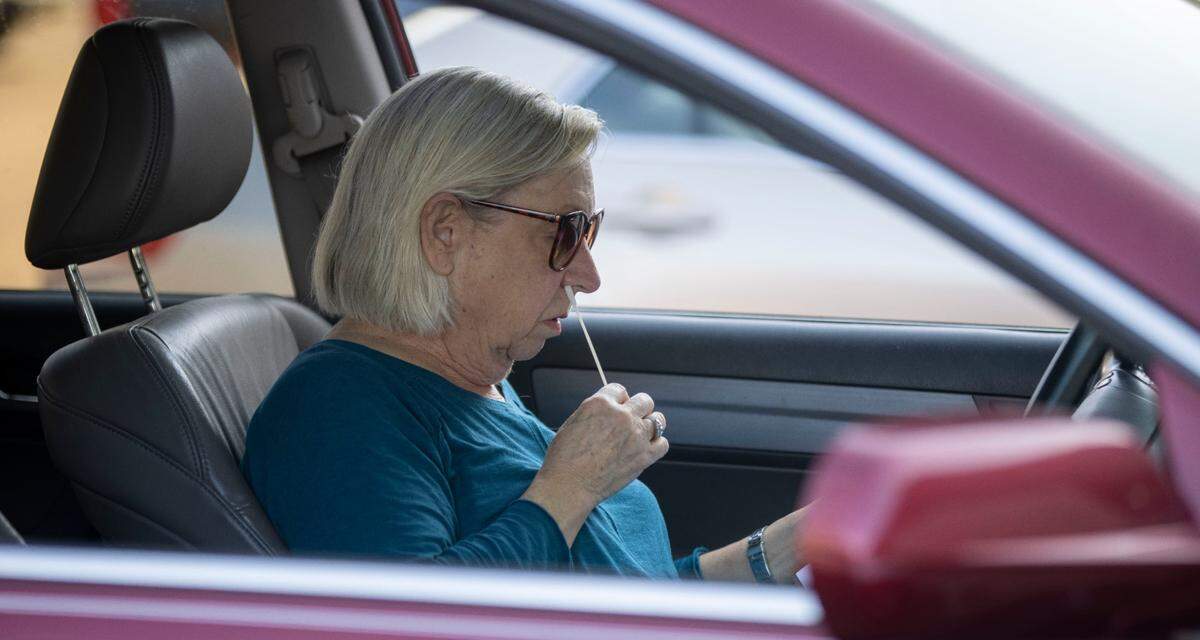 A client performs a nasal swap for a COVID-19 test at the Wake County testing site on Departure Drive on Tuesday, December 28, 2021 in Raleigh, N.C.