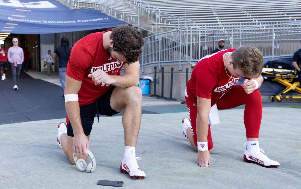 N.C. State linebacker Payton Wilson (11), left, and quarterback Ethan Rhodes (13) pray before heading out onto the field to warmup before the Wolfpack’s’ game against UConn at Rentschler Field in East Hartford, Conn. Thursday, August 31, 2023.