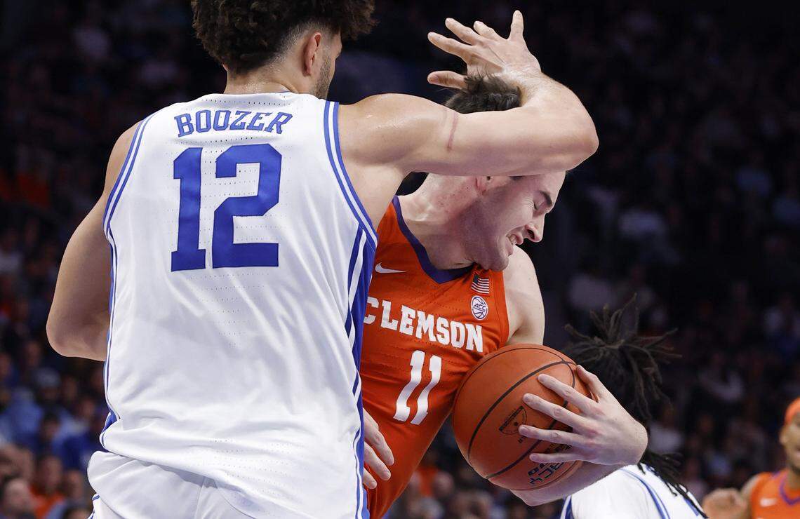 Clemson's Nick Davidson (11) tries to find space around Duke’s Cameron Boozer (12) during the first half of Duke’s game against Clemson in the semifinals of the 2026 ACC Men’s Basketball Tournament at the Spectrum Center in Charlotte, N.C., Friday, March 13, 2026.