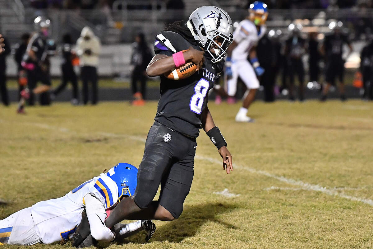 Garner defensive end Tristian Freeman (20) grapples South Garner quarterback Chase Hardy (8) after he gains the first down during the second half. The South Garner Titans and the Garner Trojans met in a conference football game in Raleigh, N.C. October 17, 2025