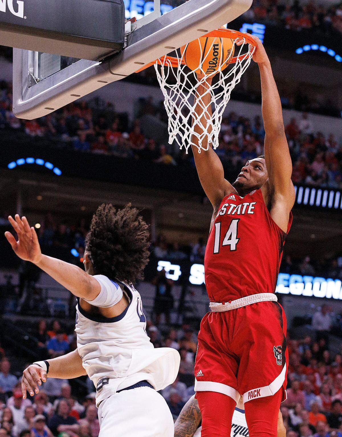 N.C. State’s Casey Morsell dunks over Marquette’s Stevie Mitchell during the first half of the Wolfpack’s NCAA Tournament Sweet 16 matchup on Friday, March 29, 2024, at American Airlines Center in Dallas, Texas.