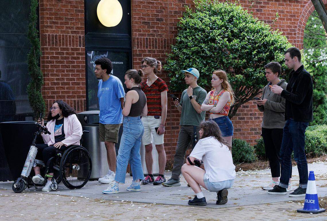 A group of students from UNC-Chapel Hill wait outside of the Alex Ewing Performance Place building on the campus of UNC School of the Arts after a meeting of the UNC System Board of Governors’ University Governance committee went into closed session on Wednesday, April 17, 2024, in Winston-Salem, N.C.