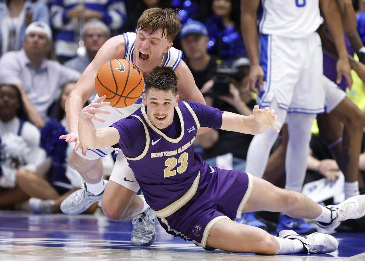 Duke’s Nikolas Khamenia (14) and Western Carolina's Marcus Kell (23) go after a loose ball during the second half of Duke’s 95-54 victory over Western Carolina at Cameron Indoor Stadium in Durham, N.C., Saturday, Nov. 8, 2025.