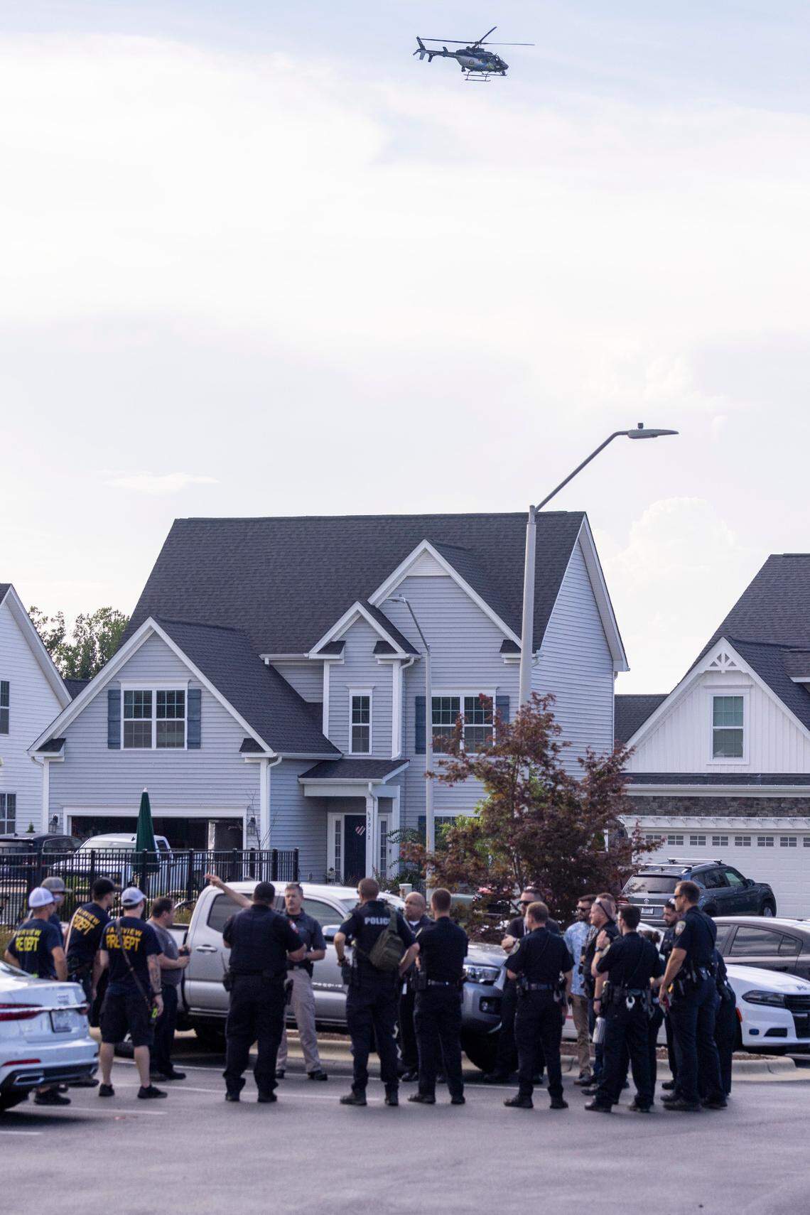 A North Carolina State Highway Patrol helicopter flies over a search area Friday, July 29, 2022 in Fuquay-Varina, NC after a twin-engine turboprop aircraft made an emergency landing at RDU International Airport and skidded off the runway. A person exited the plane prior to the emergency landing and was found dead in a Fuquay-Varina residential backyard.