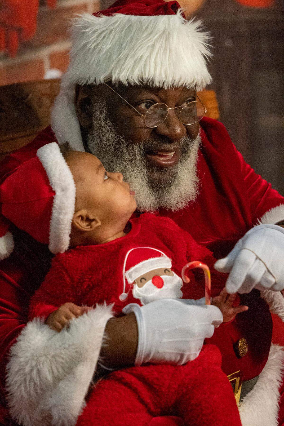 Nine-month-old Greyson Hayes has his photograph taken with Santa Claus, aka Joe Griffin or Santa Joe, at the Hayti Center in Durham Wednesday, Dec. 21, 2022.