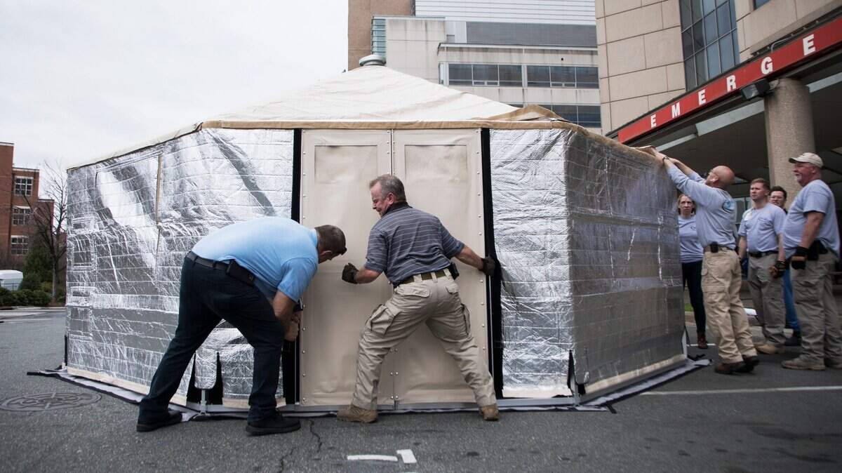Members of the State Medical Assistance Team assemble a triage tent outside of UNC Health’s emergency department in Chapel Hill, NC on Tuesday, March 17, 2020. The tent will not be used for COVID-19 testing, but to see patients coming to the ER who could be seen at another facility. The tents will help reduce the number of people in the hospital, protecting vulnerable patients.