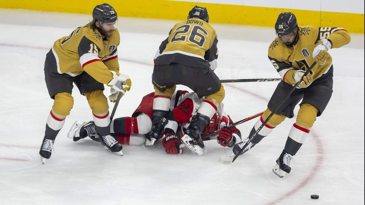 Vegas Nic Dowd (26) checks Carolina Hurricanes right wing Andrei Svechnikov (37) to the ice in the first period, as teammates Noah Hanifin (15) and Keegan Kolesar (55) take control of the puck in the first period in Game 3 of the Stanley Cup Final, on Saturday, June 6, 2026 at T-Mobile Arena in Las Vegas, NV.