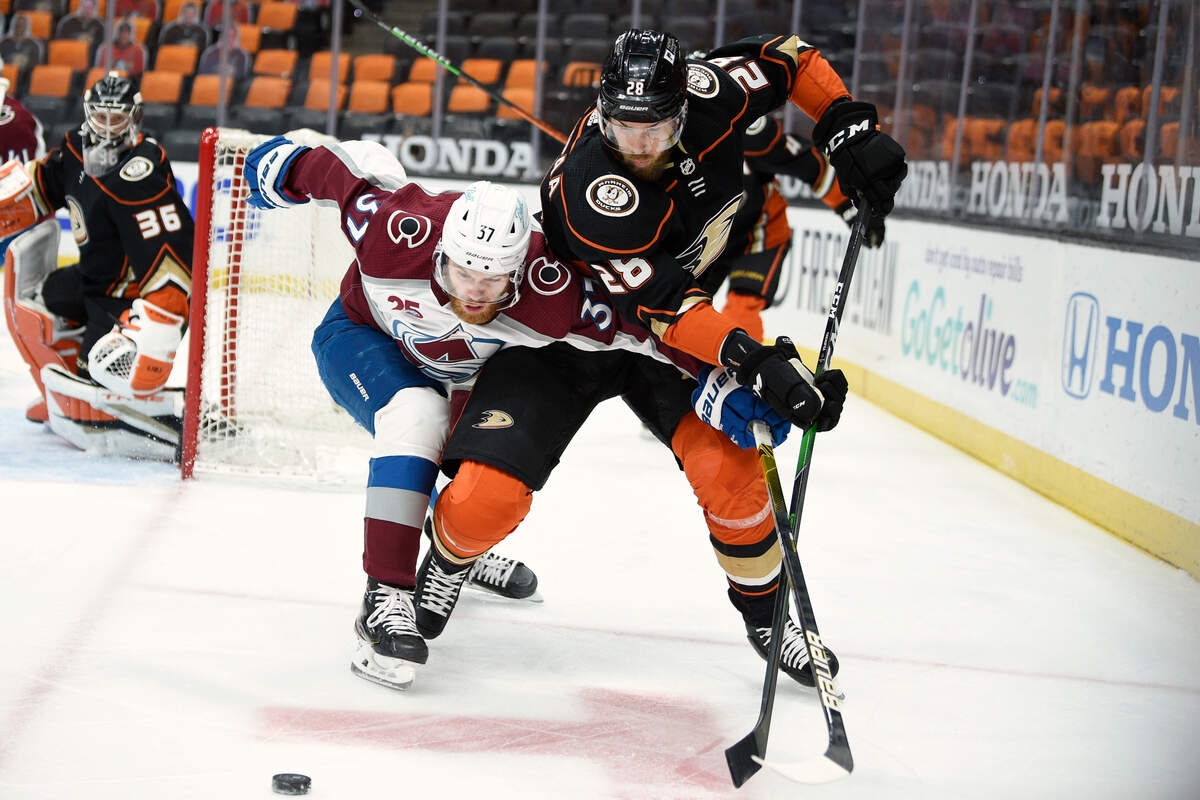 Colorado Avalanche left wing J.T. Compher, left, battles for the puck with Anaheim Ducks defenseman Jani Hakanpaa during the first period of an NHL hockey game in Anaheim, Calif., Friday, April 9, 2021. (AP Photo/Kelvin Kuo)