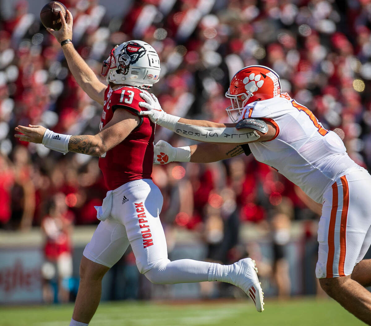 Clemson’s Bryan Bresee (11) pressures N.C. State quarterback Devin Leary (13) in the second quarter on Saturday September 25, 2021 at Carter-Finley Stadium in Raleigh, N.C.