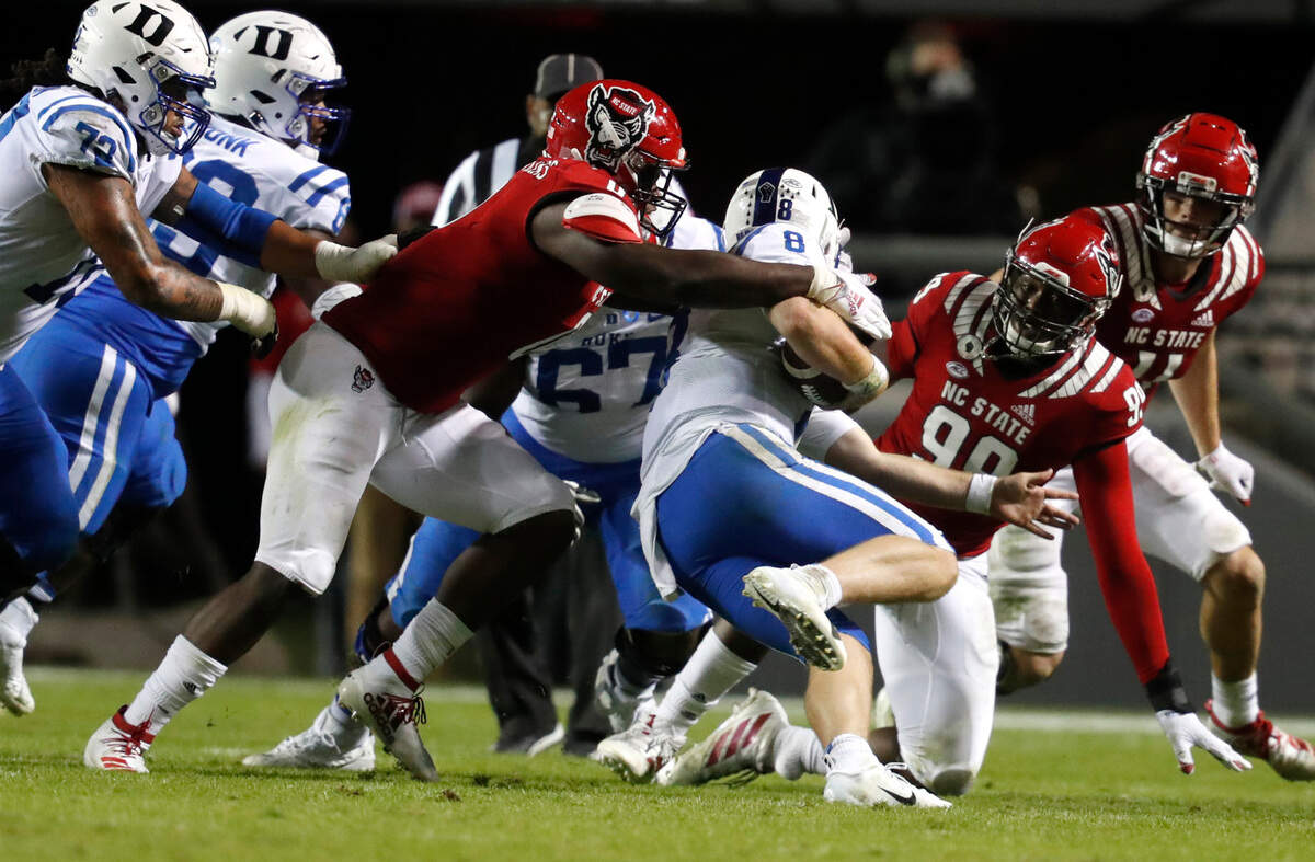 N.C. State defensive end Terrell Dawkins (0) sacks Duke quarterback Chase Brice (8) during the second half of N.C. State’s 31-20 victory over Duke at Carter-Finley Stadium in Raleigh, N.C., Saturday, Oct. 17, 2020.