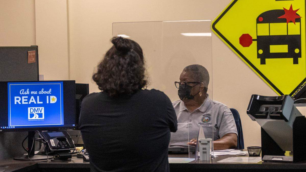 Drivers license examiner Marie Moore helps Bryan Main apply for a drivers license prior to a driving test at the N.C. Division of Motor Vehicles’ driver license office in West Raleigh on Sept. 2, 2022.