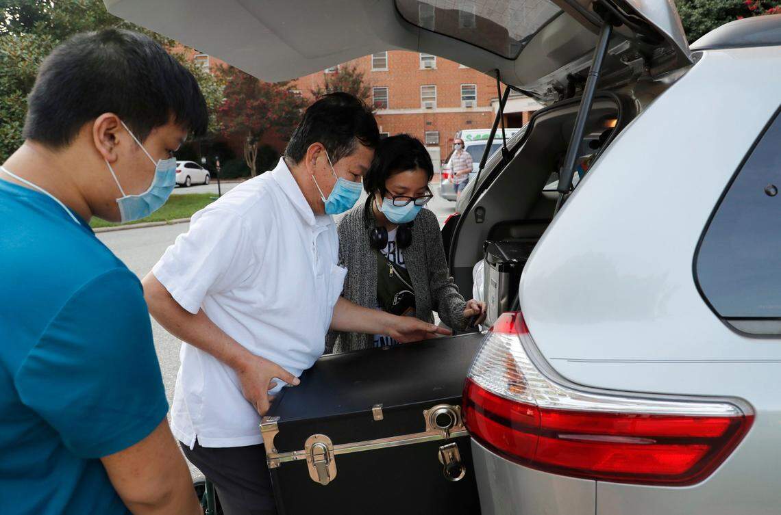 Dana Chau, right, a freshman at UNC-Chapel Hill from Mint Hill, N.C., is helped by her father Qui Chau, center, and brother, David while moving out of her room at Hinton James residence hall in Chapel Hill, N.C., Tuesday, August 18, 2020.