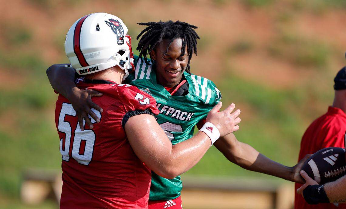 N.C. State quarterback CJ Bailey (16) hugs offensive lineman Zeke Correll (56) during the Wolfpack’s first practice in Raleigh, N.C., Wednesday, July 31, 2024.