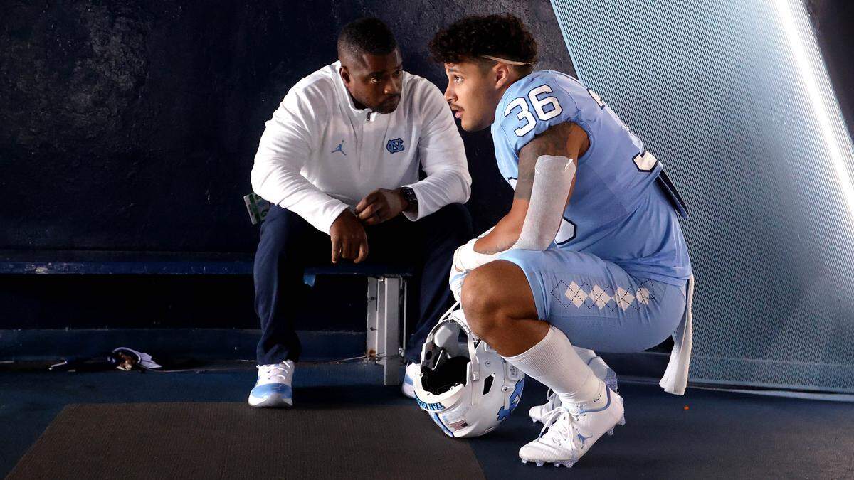 North Carolina team chaplain Mitch Mason, talks with Jalen Brooks on Saturday, October 1, 2022 at Kenan Stadium in Chapel Hill, N.C. 