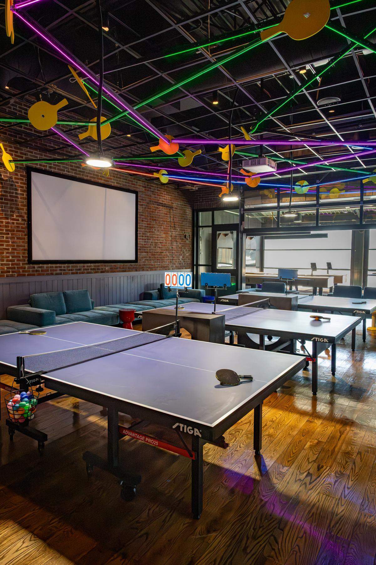 The Paddle Room features three ping pong tables and a TV projector.