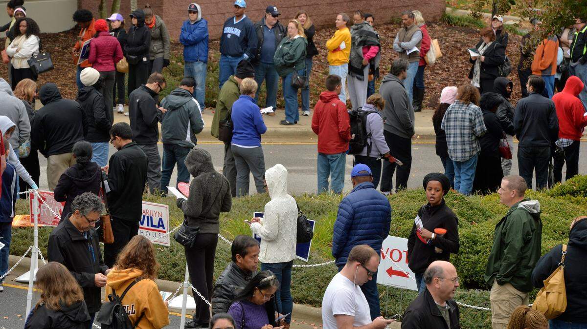 A long line of several hundred voters snakes through the parking lot of the Herb Young Community Center in downtown Cary, NC less than an hour before the end of early voting Saturday, Nov. 1, 2014.