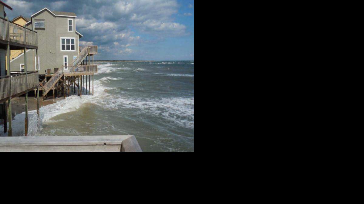 Waves lapped at these homes on North Topsail Beach on Oct. 5, where crews are now constructing a large wall of sandbags.
