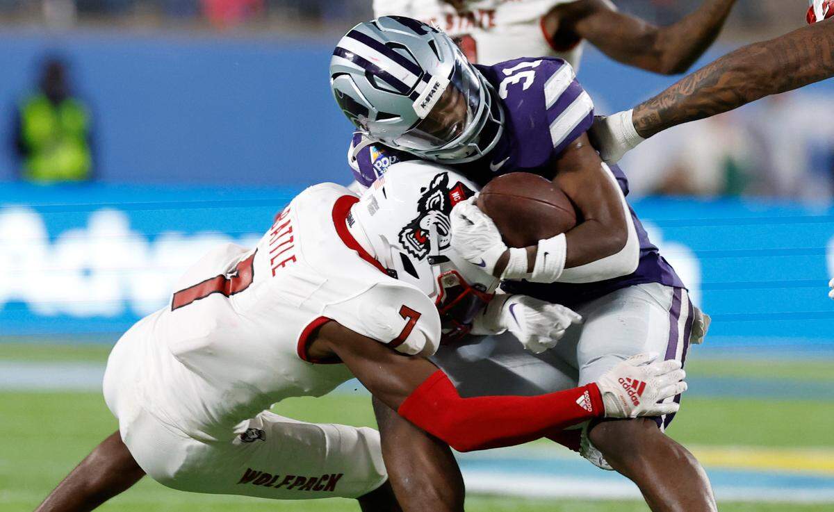 N.C. State’s Shyheim Battle (7) tackles Kansas State’s DJ Giddens (31) during the second half of Kansas State’s 28-19 victory over N.C. State in the Pop-Tarts Bowl at Camping World Stadium in Orlando, Fla., Thursday, Dec. 28, 2023.