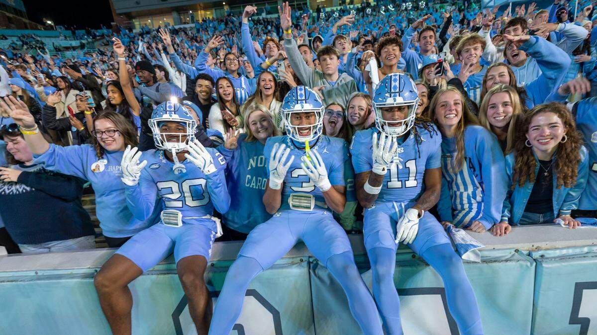 North Carolina defensive backs Jason Thompson (20), Malcolm Ziglar (3) and Ty Adams (11) jump into the student section at the start of the fourth quarter of play against Wake Forest on Saturday, November 16, 2024 at Kenan Stadium in Chapel Hill, N.C.