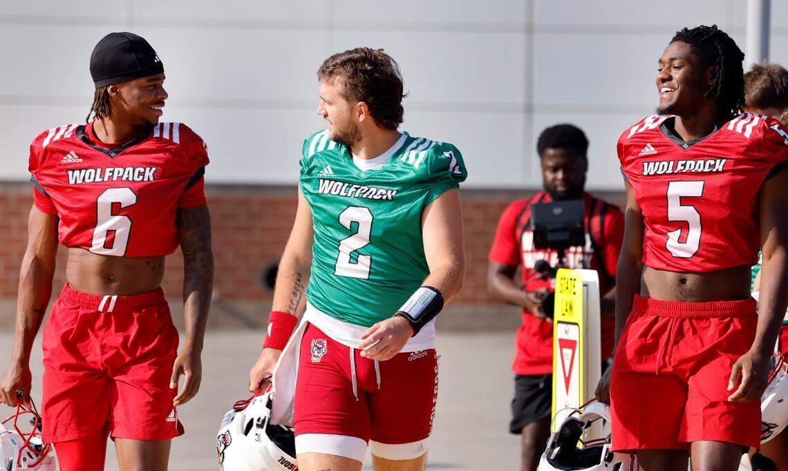 N.C. State quarterback Grayson McCall (2) talks with wide receivers Wesley Grimes (6) and Noah Rogers (5) as they head out to the field before the Wolfpack’s first practice in Raleigh, N.C., Wednesday, July 31, 2024.