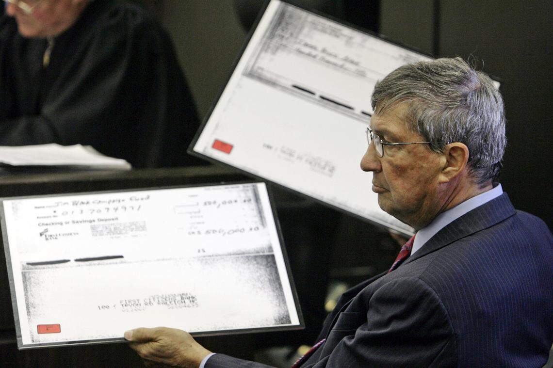 Former Speaker of the N.C. House of Representatives James Black, right, looks over some large copies of the $500,000 checks presented as evidence in his court proceedings in a Wake County courtroom in July 2007.