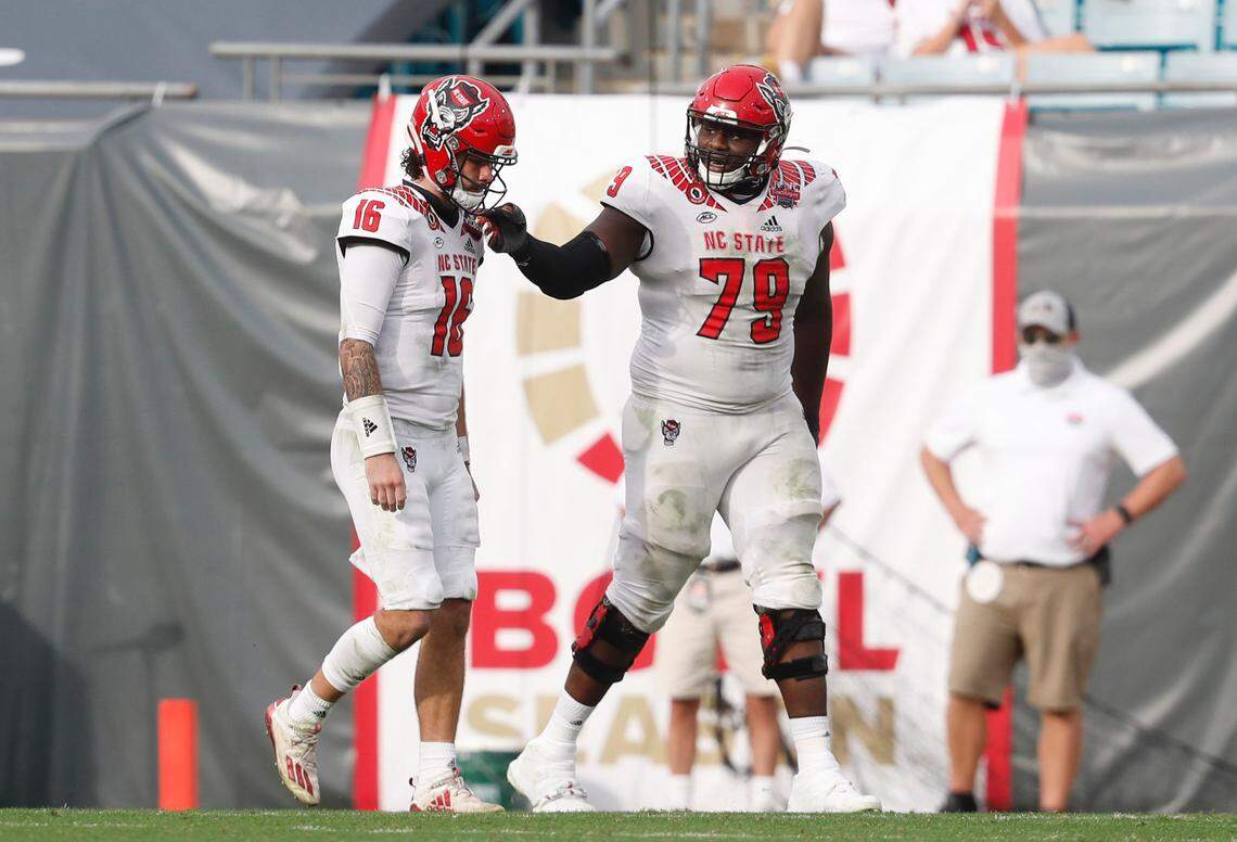 N.C. State offensive tackle Ikem Ekwonu (79) tells quarterback Bailey Hockman (16) to keep his head up after Hockman threw an interception late in the second half of Kentucky’s 23-21 victory over N.C. State in the Gator Bowl at TIAA Bank Field in Jacksonville, Fla., Saturday, January 2, 2021.