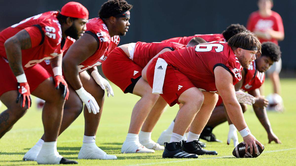 Members of the N.C. State offensive line, from left, Jacarrius Peak (65), Timothy McKay (52) and Zeke Correll (56) run a drill during the Wolfpack’s first practice in Raleigh, N.C., Wednesday, July 31, 2024.