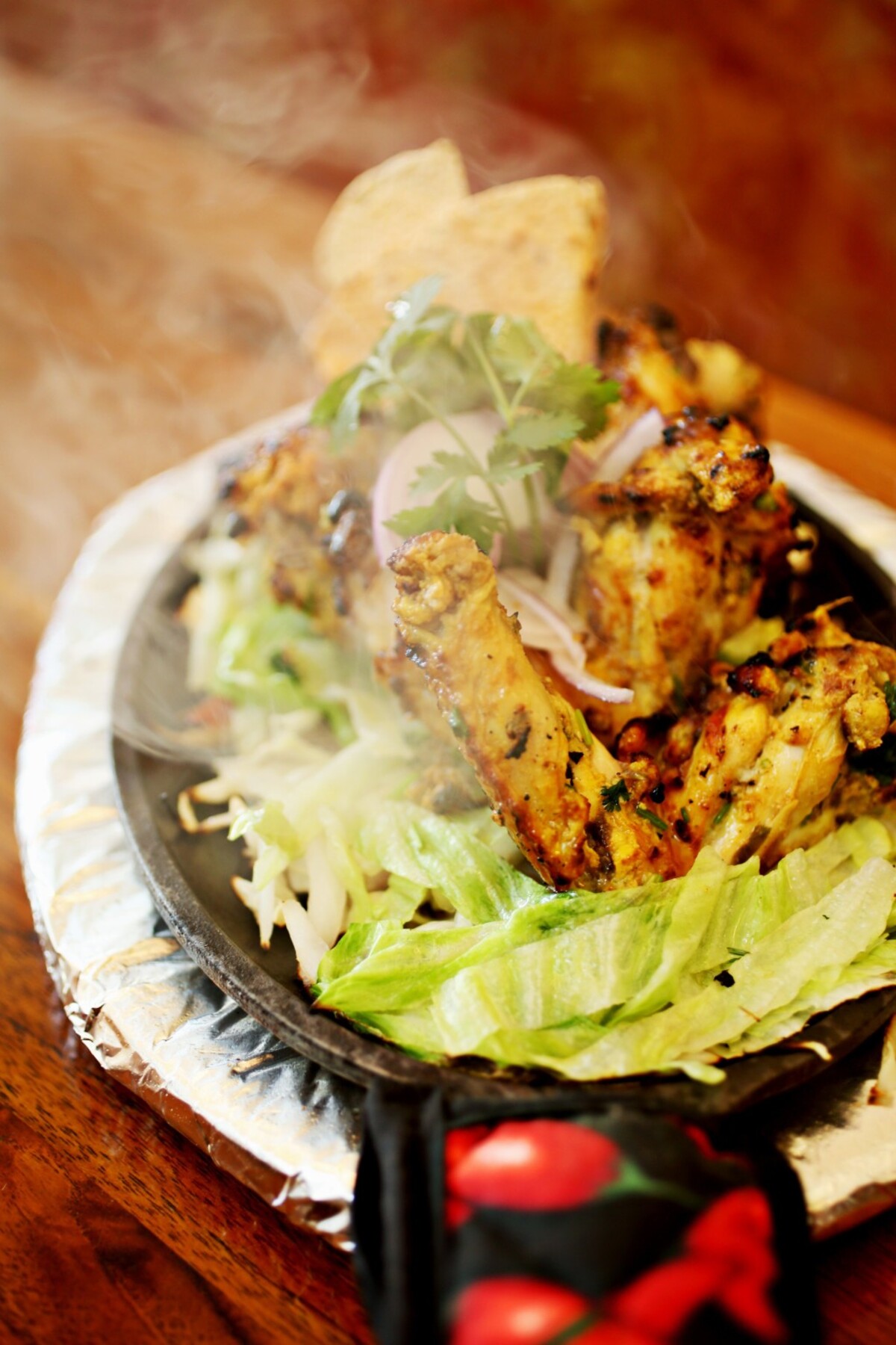 Persis Indian Grill’s Tandoori-grilled Lahsuni Wings are succulent in their char-mottled skins that arrive on a sizzling bed of peppers and onions on a cast iron platter.