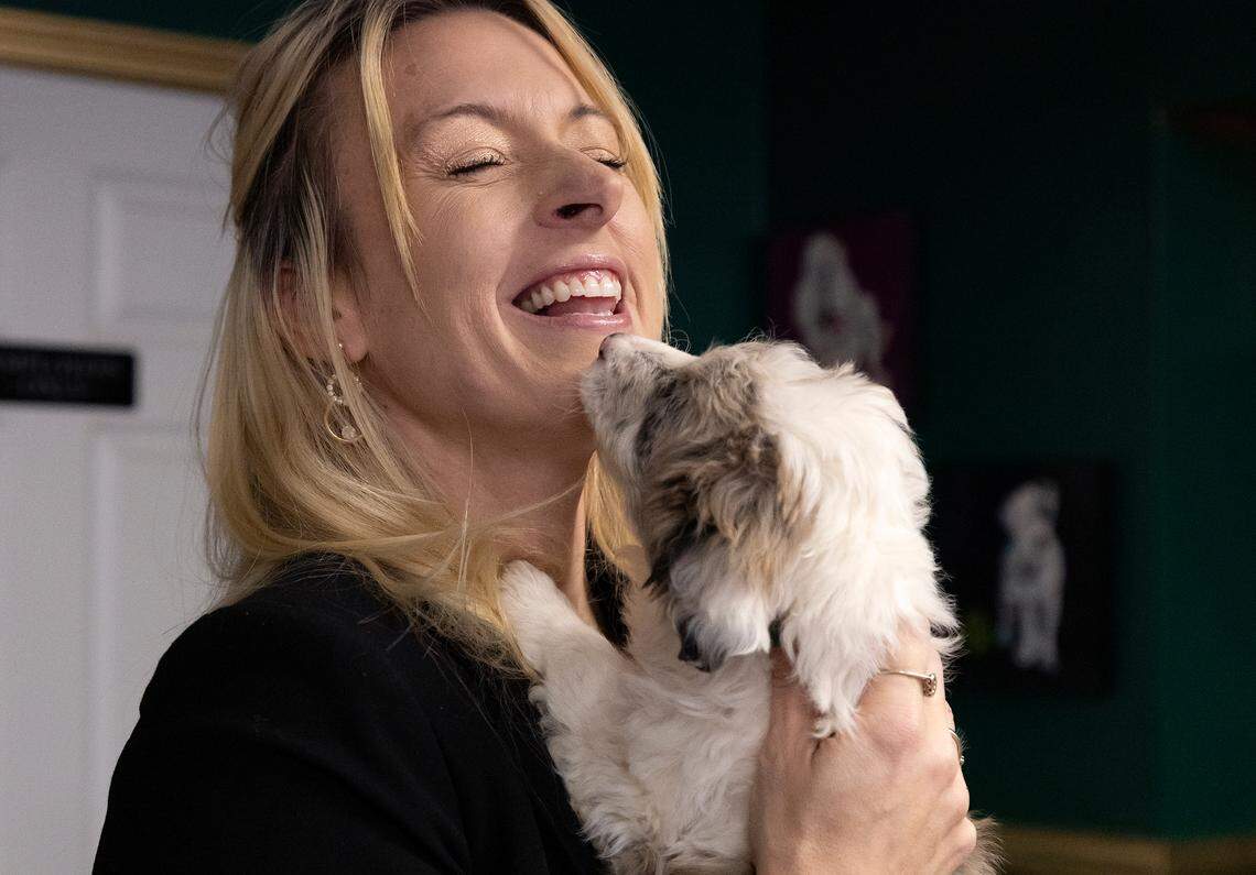 Jacklyn Barefoot, owner of Petopia, smiles while holding Paisley, an eight-week-old Aussiedoodle puppy, at her store in downtown Raleigh, N.C. on Tuesday, Jan. 14, 2025.