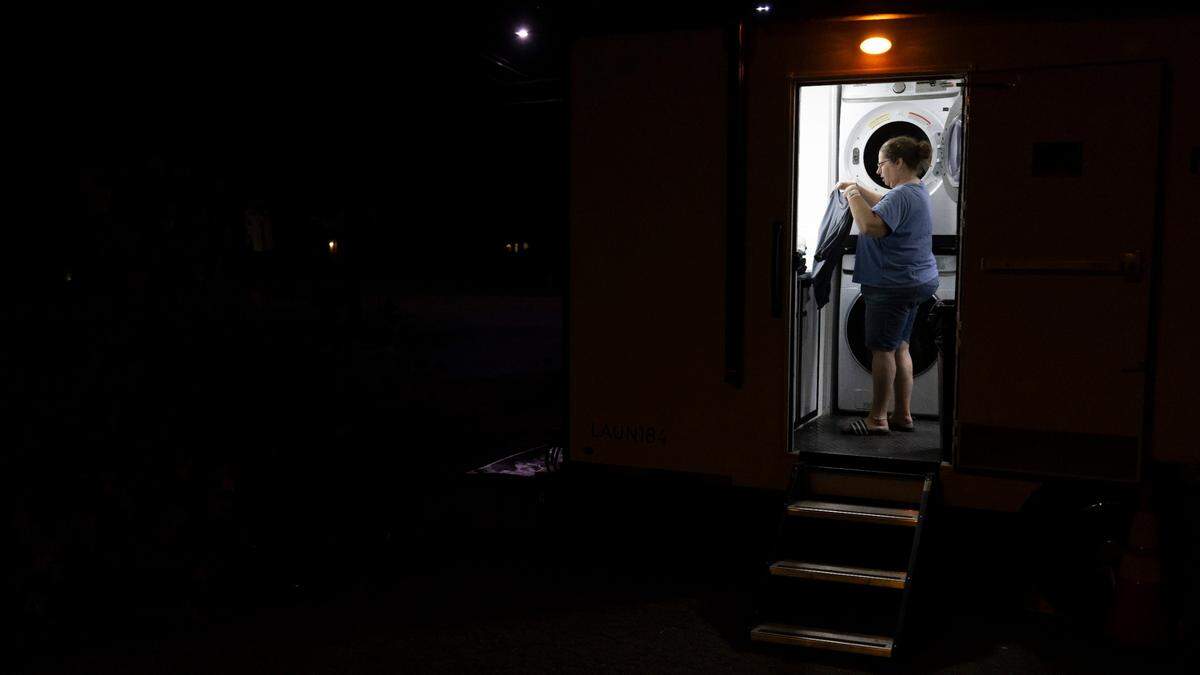 Piper Parker, of Old Fort, N.C., without power in her home since Hurricane Helene hit on September 27, uses a free, portable laundry unit at the First Baptist Church on Tuesday, October 8, 2024 in Old Fort, N.C.