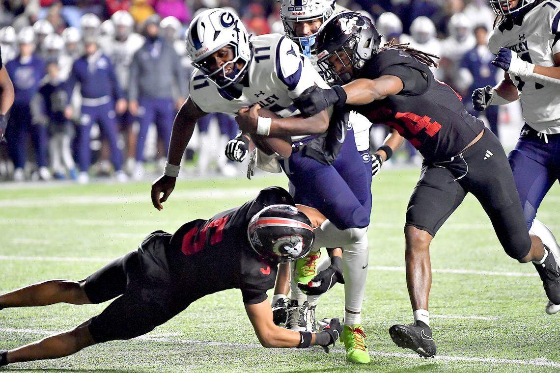 Grimsley quarterback Faizon Brandon (11) rushes for yards against Rolesville’s PJ Hartsfield, Jr. (5) and Jayden Griffin-Haynes (24) during the second half. The Rolesville Rams and the Greensboro Grimsley Whirlies met in the NCHSAA 4A football Championship Game in Chapel Hill, N.C. on December 20, 2024.