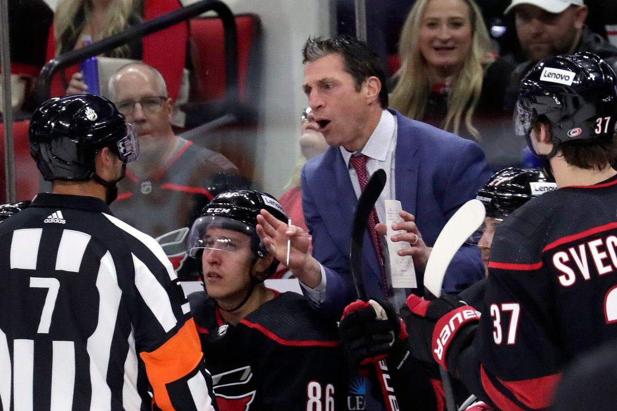 Carolina Hurricanes head coach Rod Brind’Amour, center right, dicusses a call with an official (7) during the second period of an NHL hockey game against the Chicago Blackhawks, Friday, Oct. 29, 2021, in Raleigh, N.C. (AP Photo/Chris Seward)