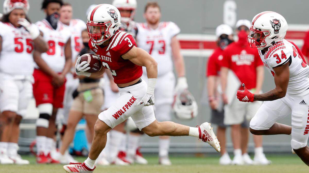 N.C. State running back Jordan Houston (3) runs past N.C. State cornerback Nate Evans (34) during the first half of N.C. State football’s spring game at Carter-Finley Stadium in Raleigh, N.C., Saturday, April 10, 2021.